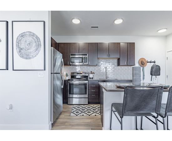 a kitchen with wooden cabinets and stainless steel appliances at RockVue, Broomfield, CO